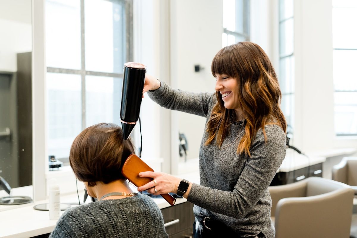 Hair stylist preparing a client consultation in a salon mirror
